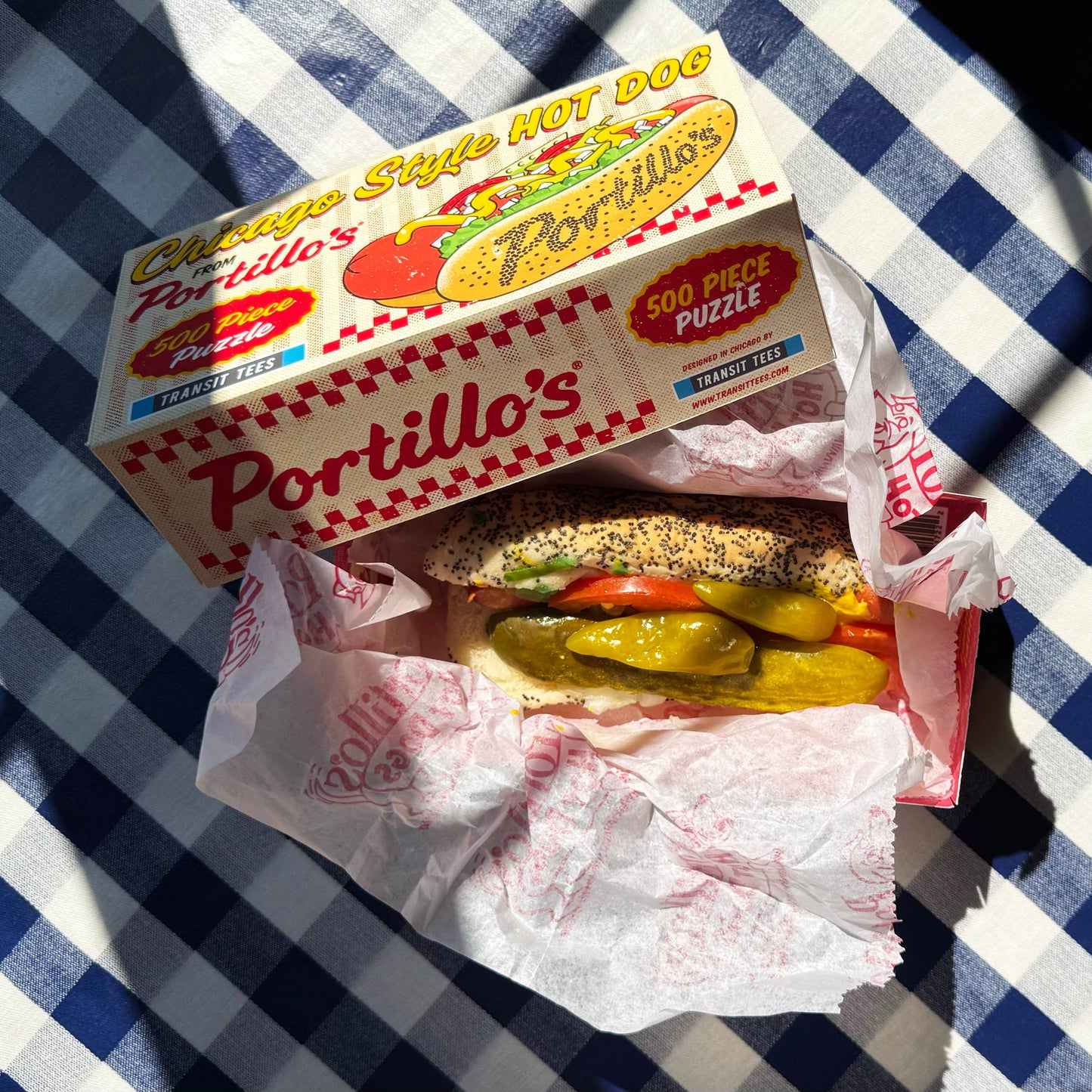 Hot dog with Portillo's branding on a checkered tablecloth