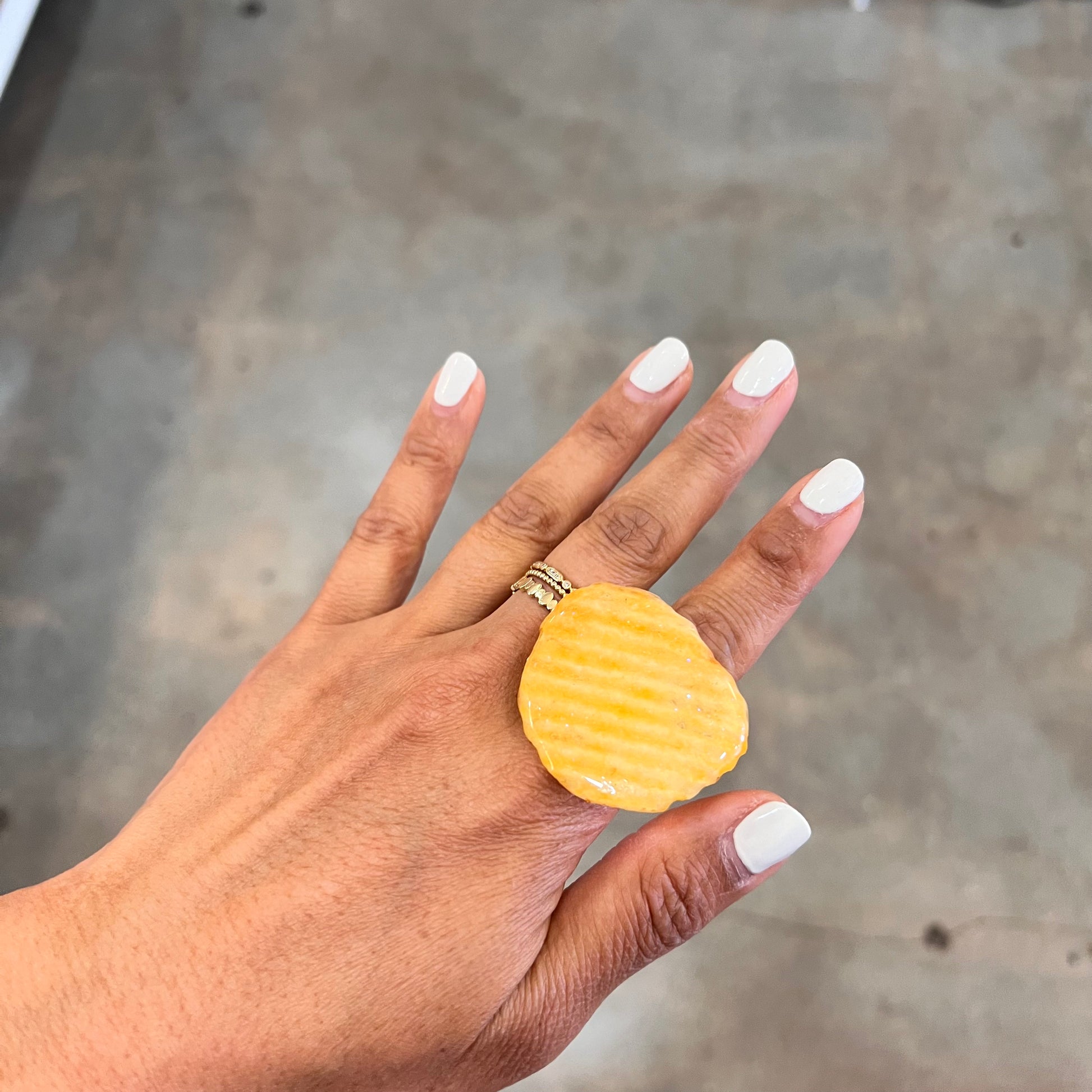 Hand wearing a Ruffles ring dipped in resin.