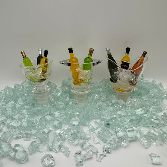 3 various wine stoppers that look like wines in an ice bucket.