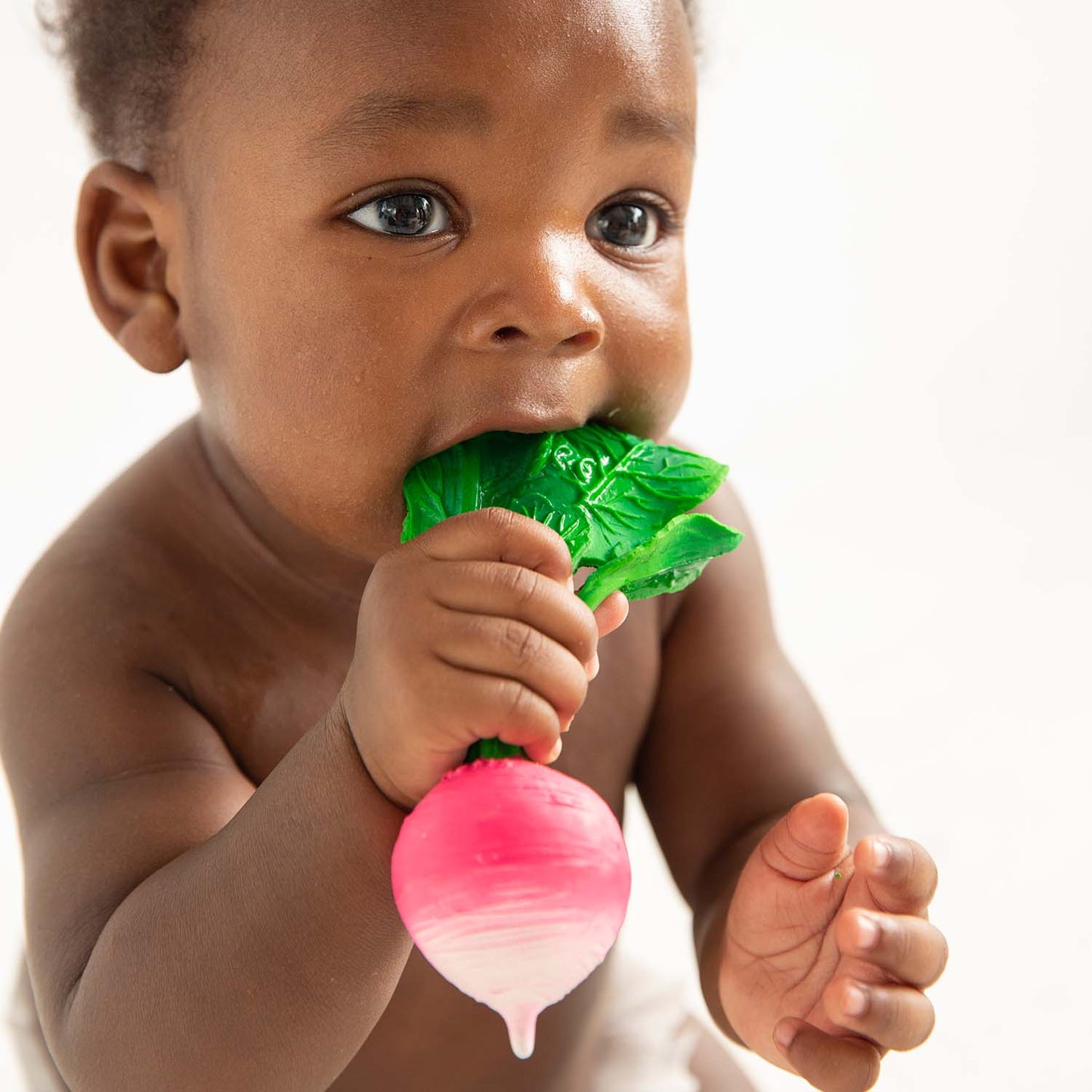 Photo of baby teething on radish-shaped baby toy.