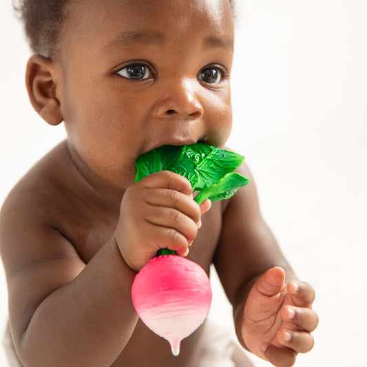 Photo of baby teething on radish-shaped baby toy.