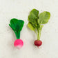 Photo of radish baby toy side-by-side with actual radish.
