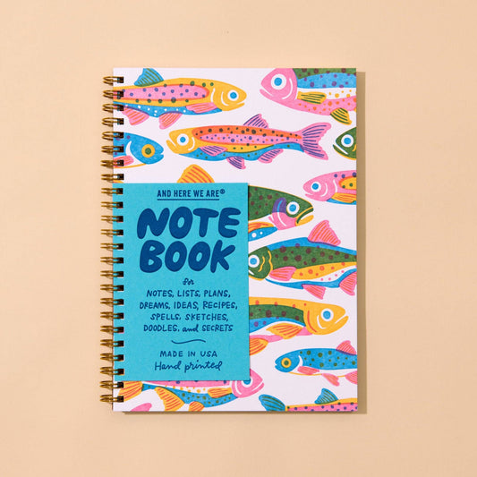Notebook with colorful rainbow trout fish design on a beige background