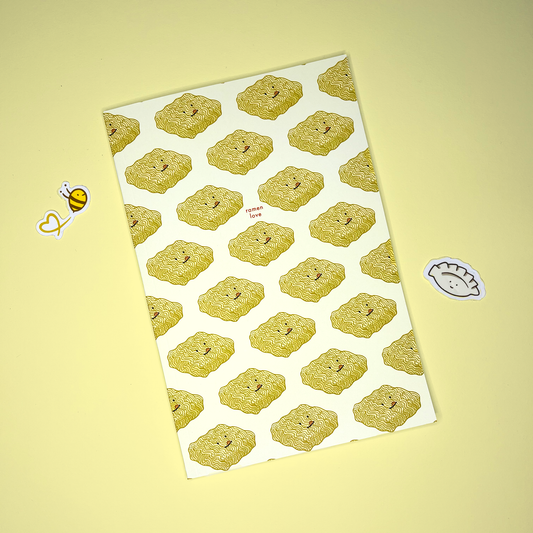 Notebook with a design pattern of dried ramen noodles all over and smal text in center that reads "ramen love" 