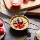 candle made to look like korean ramen noodles in gold pot with toppings such as mushrooms, beef, green onions and peppers on it
