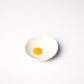Small ceramic bowl designed to look like a sunny side up egg pictured here on a white background
