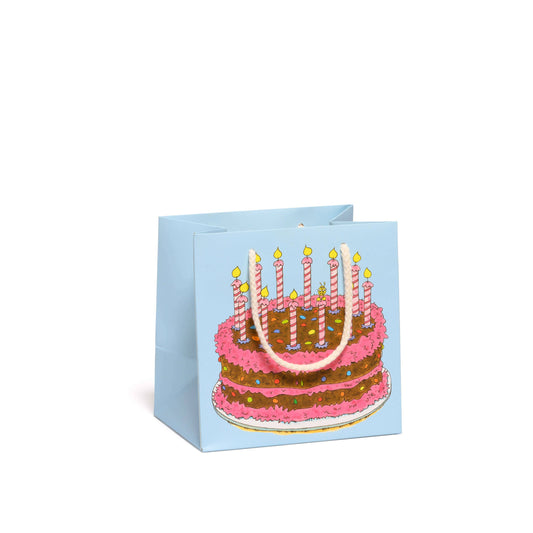 Gift bag with a birthday cake design featuring candles on a white background