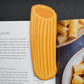 Pasta-shaped bookmark on a magazine with pasta images in the background