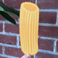 Pasta-shaped bookmark held in front of a brick wall