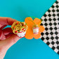 Close up/top view of the mini smiley faced ramen cup magnet with chopsticks, noodles, peas and carrots coming out the top 