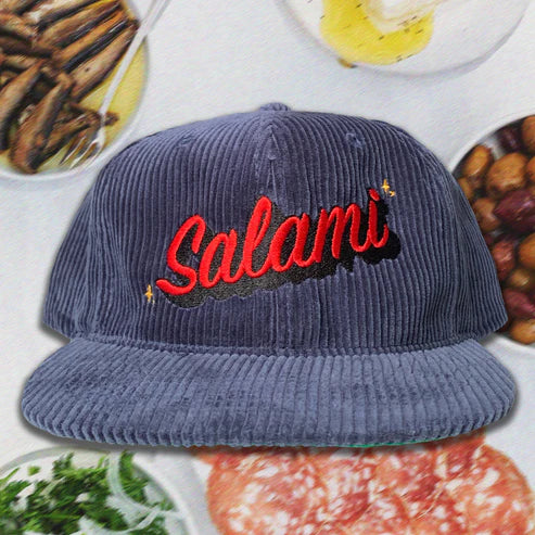 Greyish-blue corduroy dad hat with the word "Salami" embroidered in red. Vintage script font.