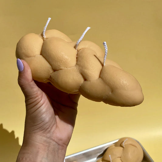 Challah candle being held in a hand for size reference.