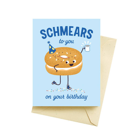 Birthday card with a cartoon bagel with schmear and text 'Schmears to you on your birthday' on a light blue background.
