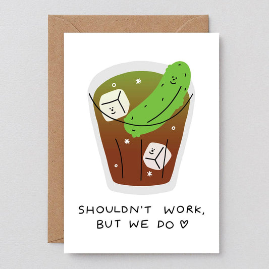 Greeting card with a cartoon pickle in a cup and text 'Shouldn't work, but we do' on a white background.