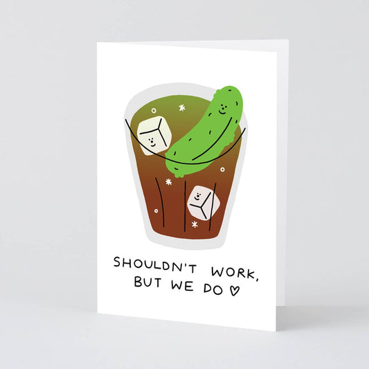 Illustrated card with a pickle in a glass, with text 'SHOULDN'T WORK, BUT WE DO', on a white background.