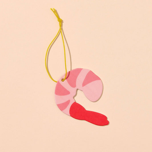 shrimp shaped air freshener on yellow string on light background 