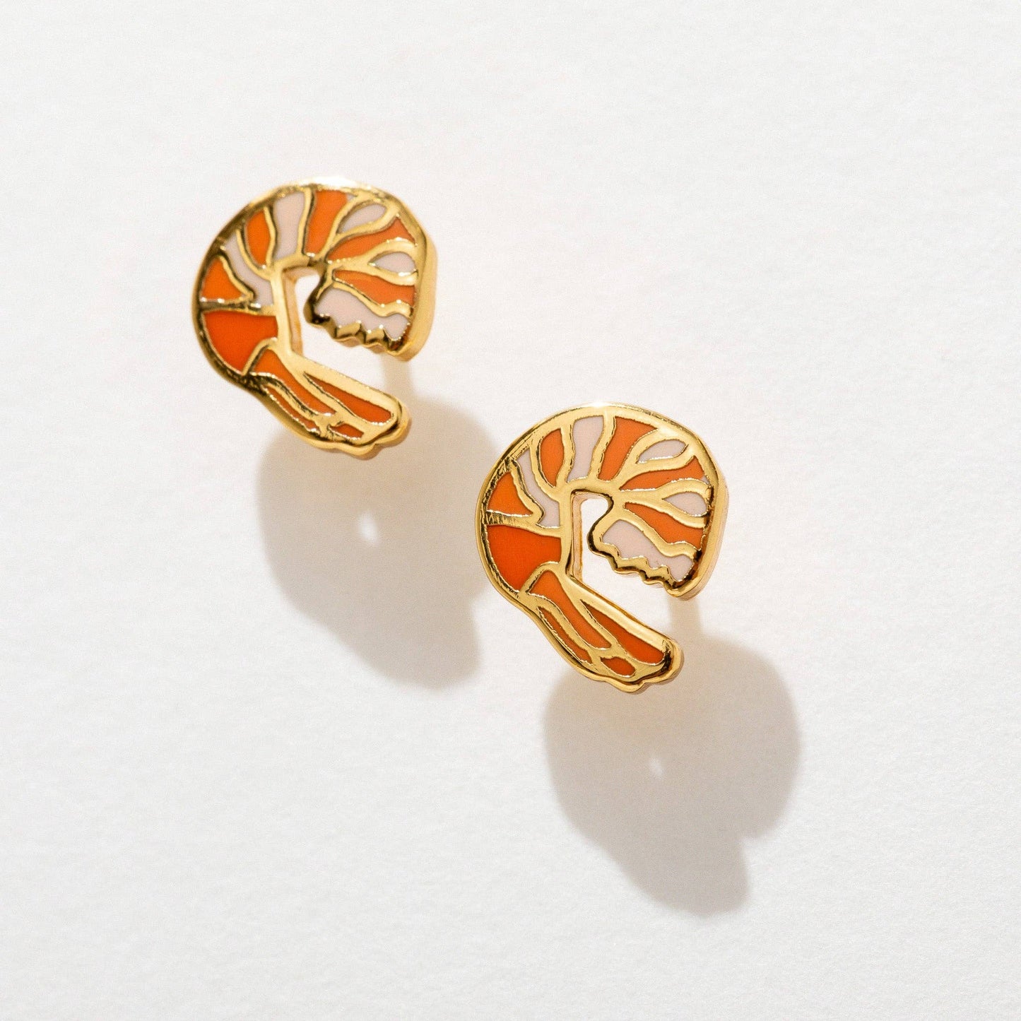 Pair of earrings with a shrimp design on a light gray background