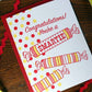 Card with candy illustrations and 'Congratulations! You're a SMARTIE' text on a wooden surface