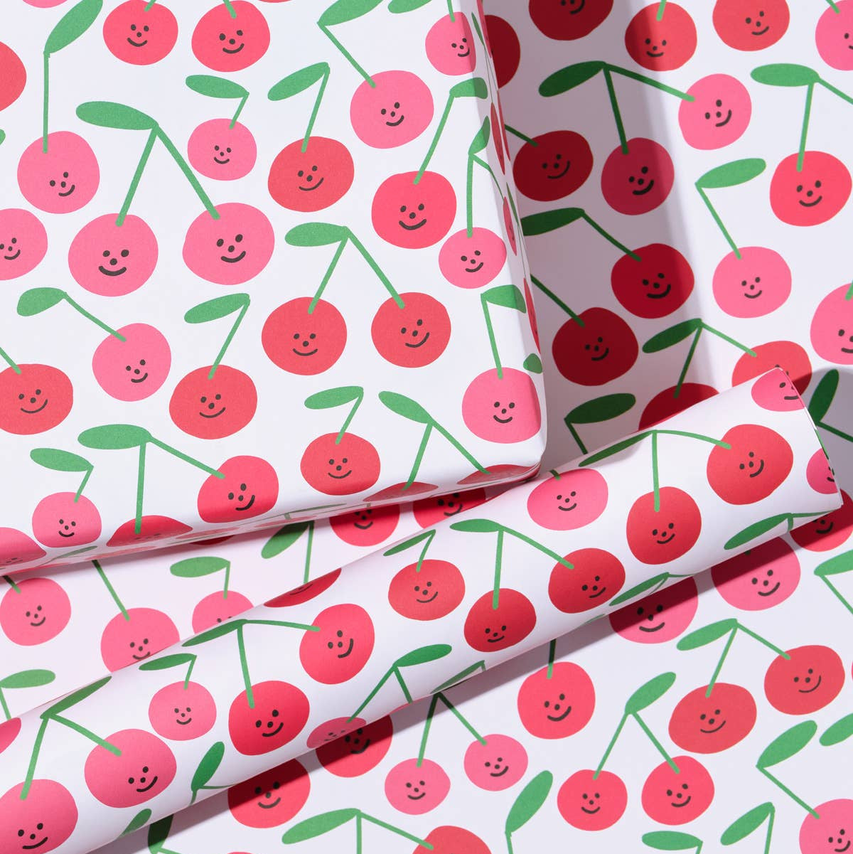 close up of the gift wrap sheet with a smiley-faced cherry design all over 