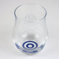 Angled view of tulip shaped sake tasting glass with blue bullseye pattern on bottom of glass.