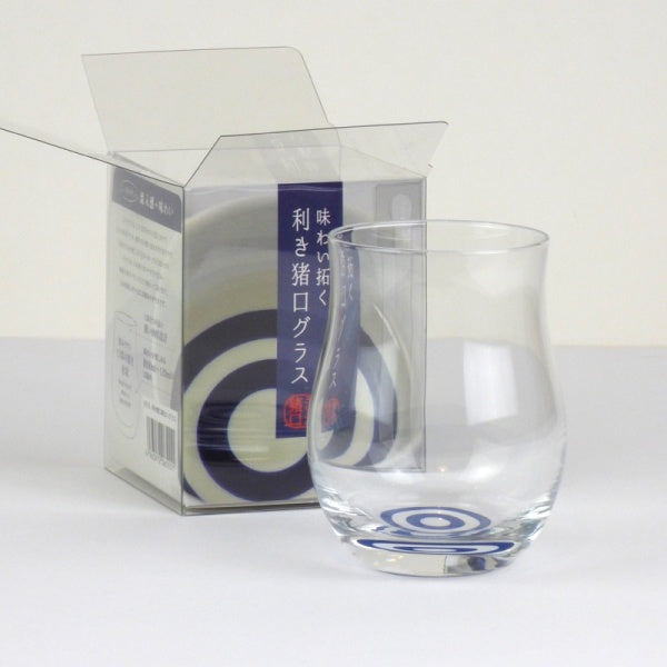 Photo of sake tasting glass and original packaging, shown as clear plastic box with Japanese writing.