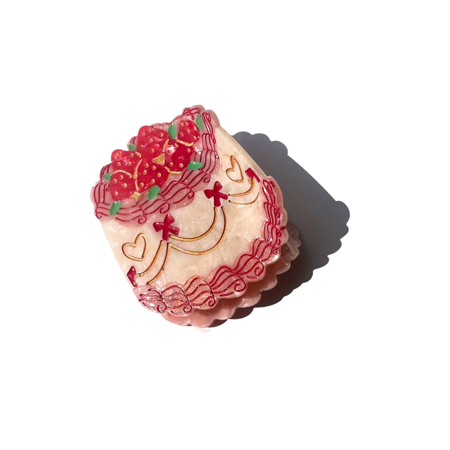 Cake hair claw in shades of red and pink. Detailed shell piping, bows, and strawberries.