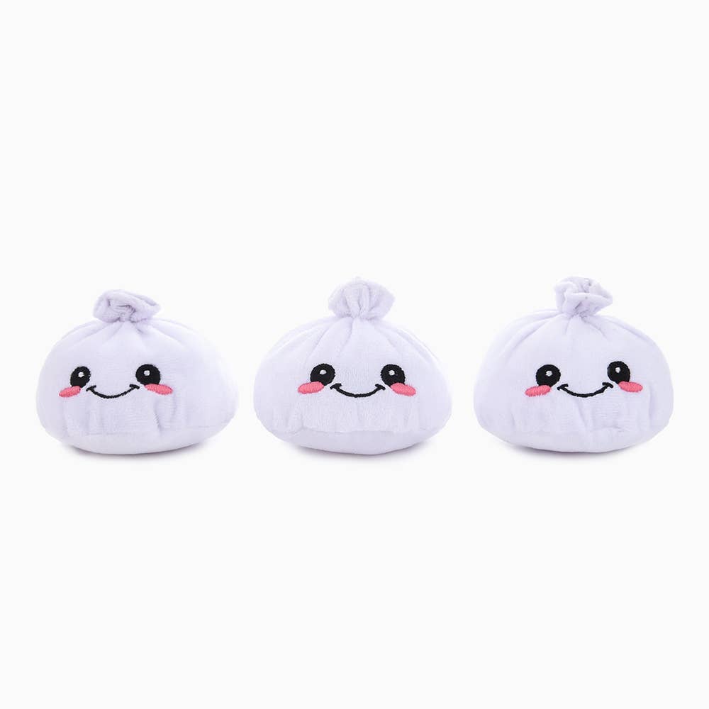 Three white plush soup dumpling dog toys with smiling faces on a white background