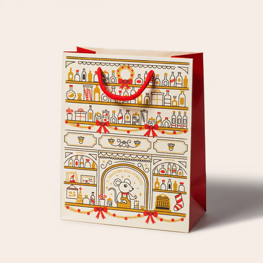 Bag features red, gold and white colors with the illustration depicting a bar with a mouse bartending and stirring a cocktail. Shelves are lined with bottles and adorned with a wreath, garlands and bows 