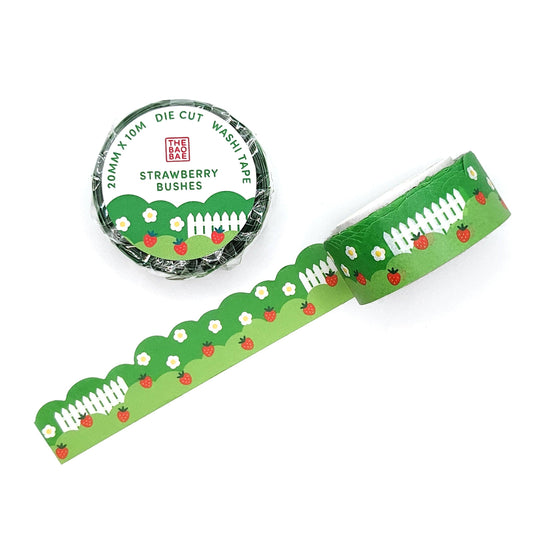 Green washi tape with strawberry bush and white picket fence design and packaging on a white background