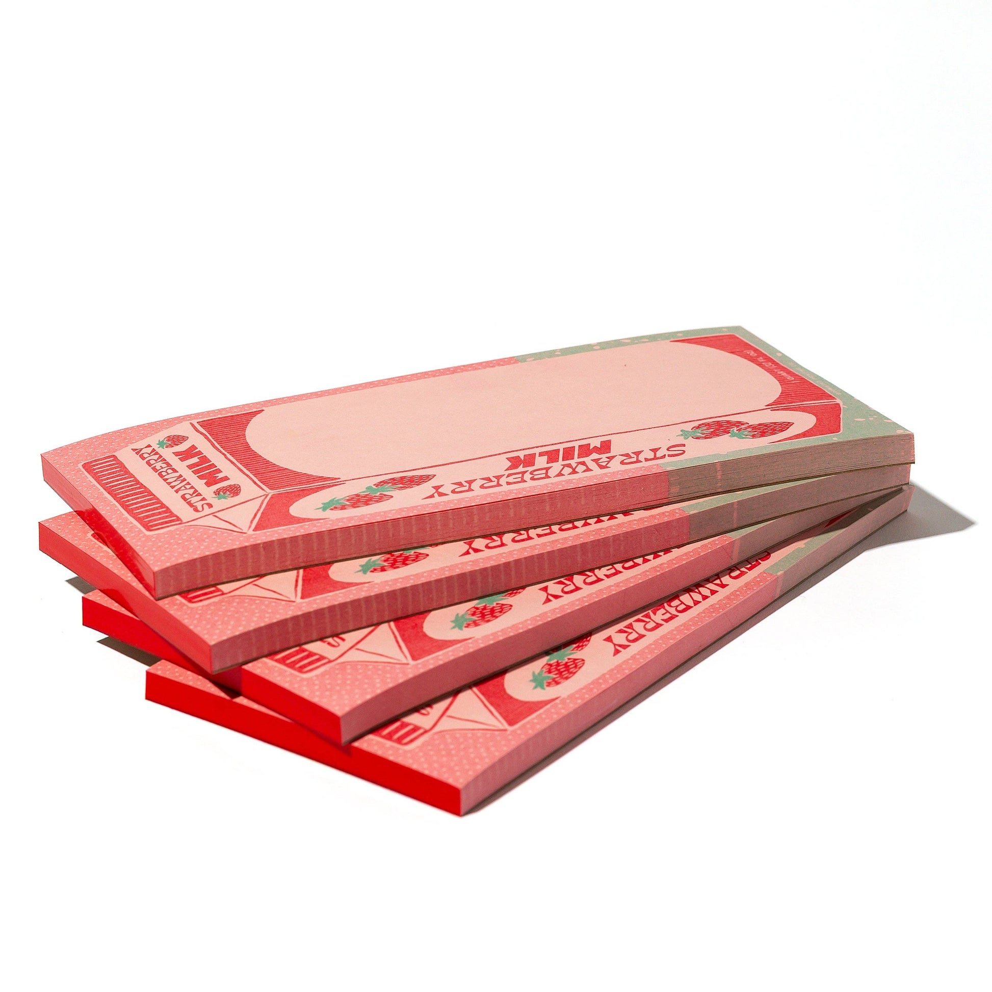 Stack of pink and red strawberry milk carton notepads on a white background
