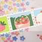 Set of colorful strawberry-themed washi stamps with a floral background