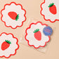 Strawberry-themed coasters with red and white design on a beige background