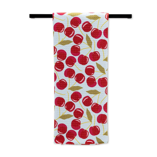 light blue towel with cherry pattern. hanging on a rod.