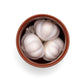 Three garlic bulbs in a terracotta pot on a white background