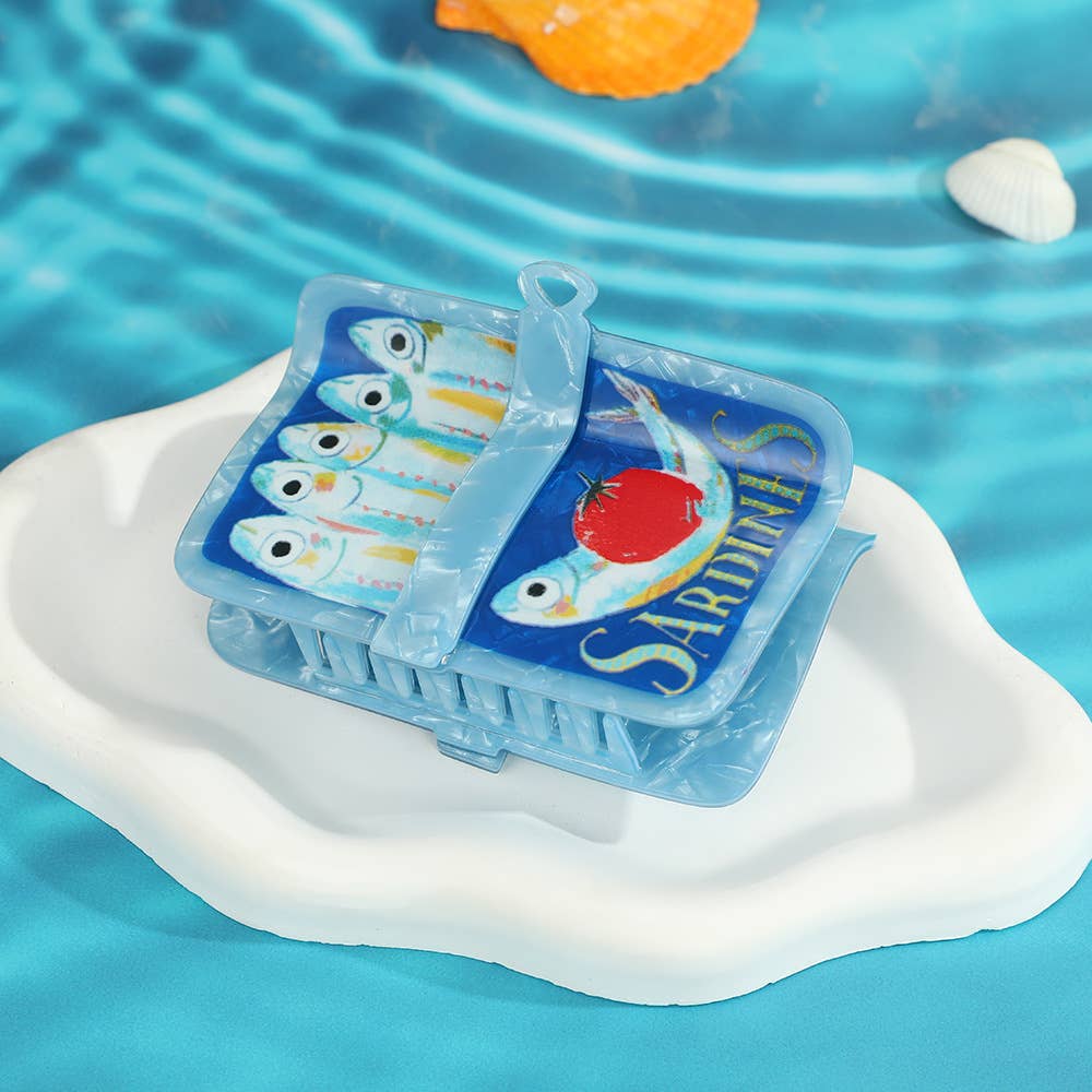 Sardine can-shaped hair claw on a blue water-like background