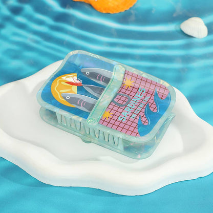 hair claw with tinned fish design on a water surface