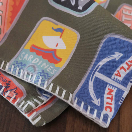 Collection of colorful tinned fish labels on a fabric background