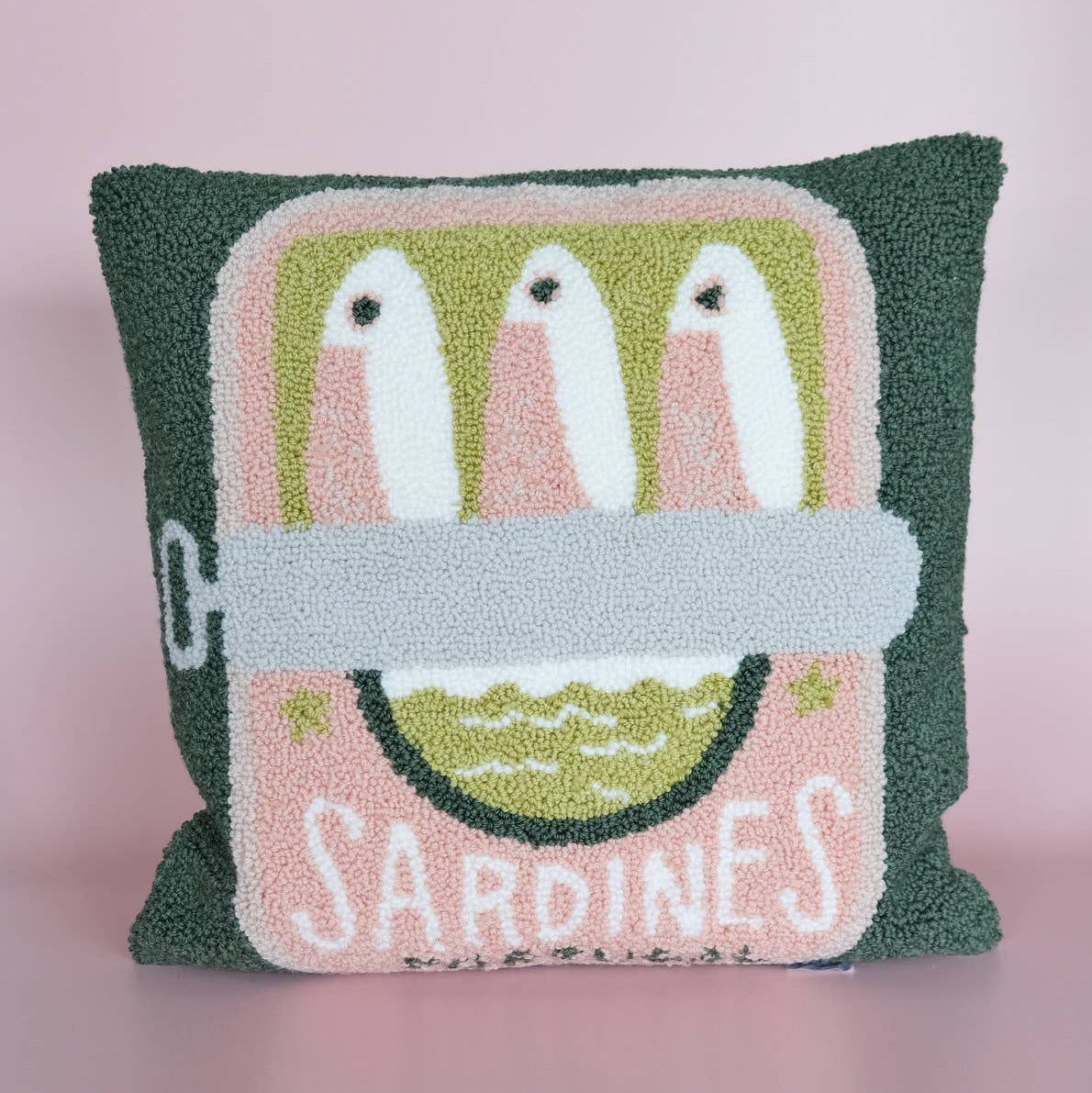 Decorative pillow with a sardine can design on a pink background
