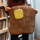 closer look at toast shaped rug with pad of butter being held up by someone