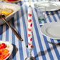 Taper candle with tomato pattern on a striped tablecloth