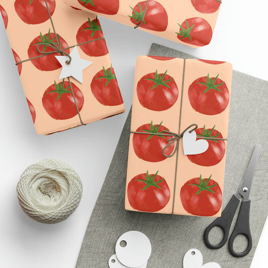 Gift wrap with tomato pattern, scissors, and yarn on a light background
