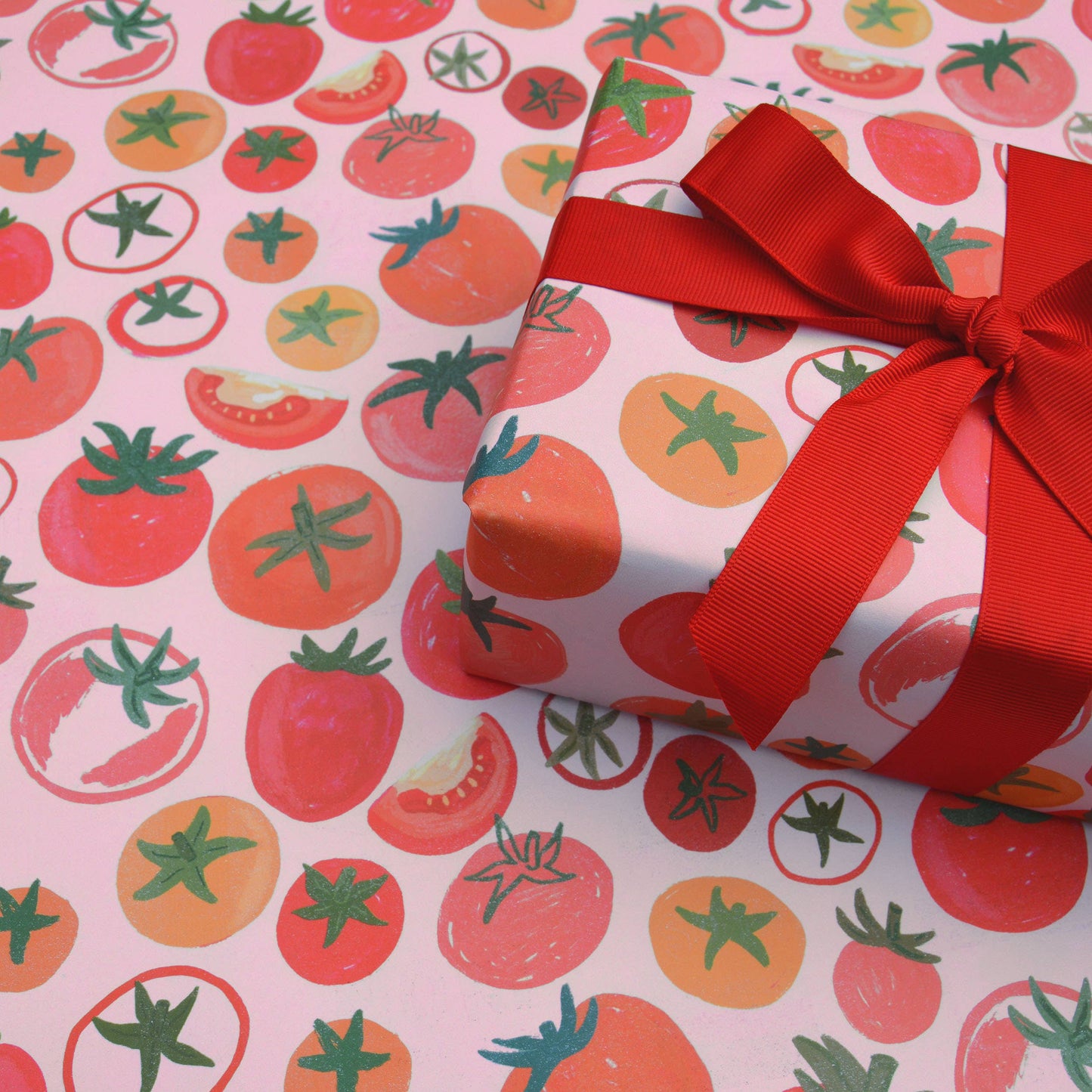 gift wrapped in tomatoes wrapping paper with red ribbon tied in a bow on top