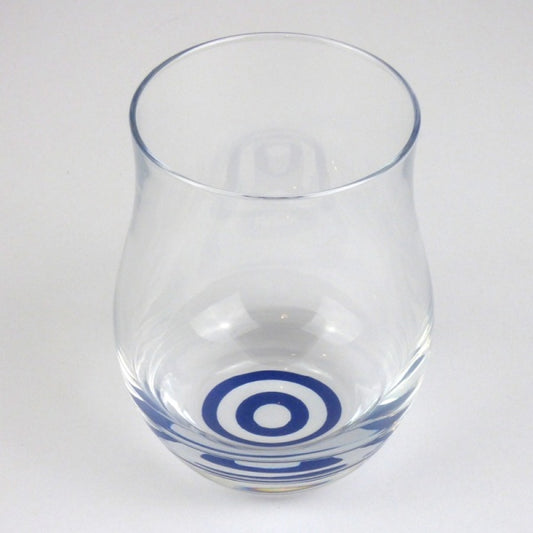 Angled view of tulip shaped sake tasting glass with blue bullseye pattern on bottom of glass.