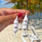 Hand holding garlic earrings -- 3 garlic bulbs in mesh sackbs