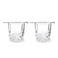 Two clear whiskey glasses with silver picks sitting on top of each one on a white background