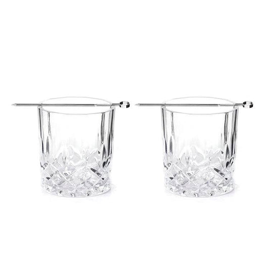 Two clear whiskey glasses with silver picks sitting on top of each one on a white background
