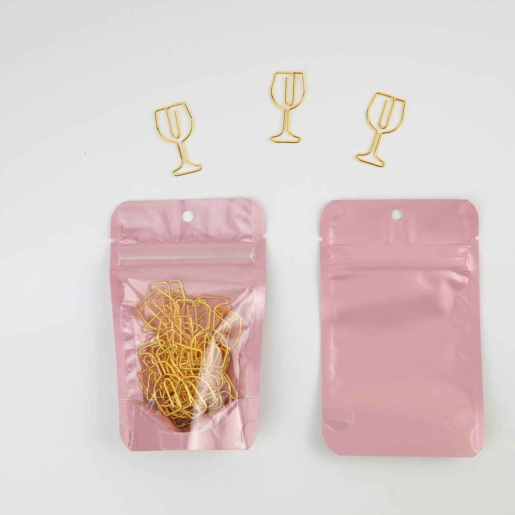 Gold wine glass-shaped paper clips in a pink packaging bag on a white background