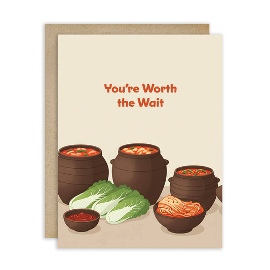 Greeting card with illustrations of Korean clay pot jars and cabbage with text that reads 'You're Worth the Wait' on a beige background.