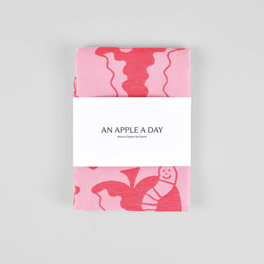 "An Apple A Day" red and pink kitchen towel wrapped in a paper band packaging