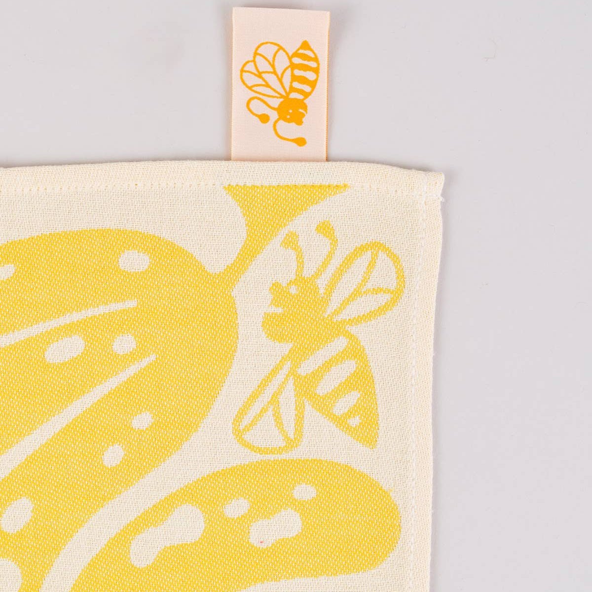 close up view of the corner/product tag of "go bananas" yellow kitchen towel 